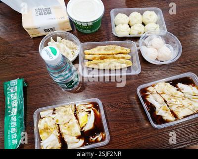 Shenzhen, China - 10. Mai 2024: Ein Blick von oben auf ein traditionelles chinesisches Essen zum Mitnehmen mit einer Auswahl an Knödeln und frittierten Artikeln auf einem Tisch. Stockfoto