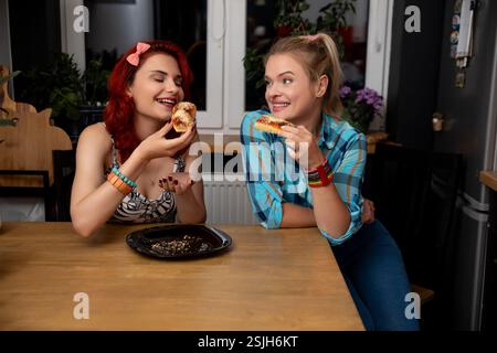 Eine Gruppe von Freunden genießt köstliche Pizza zusammen in einer gemütlichen und fröhlichen Küche Stockfoto