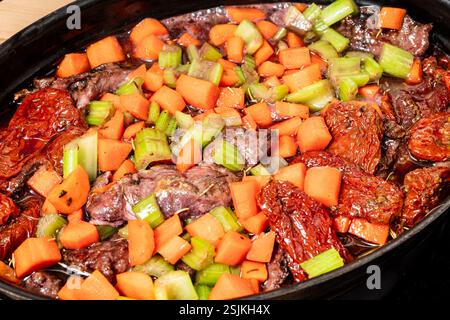 Die Zubereitung von Rinderwangen, die in Rosmarin und Gemüsesauce gebraten werden Stockfoto