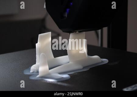 Ein Objekt, das mit einem 3D-Drucker Gestalt annimmt und das Potenzial für eine maßgeschneiderte und bedarfsgerechte Produktion in verschiedenen Bereichen demonstriert. Stockfoto