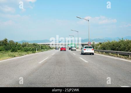 Fahren Sie auf einer Autobahn mit mediterranen Landschaften, erfassen Sie den Verkehrsfluss und die Infrastruktur, und betonen Sie den Transport in Südeuropa Stockfoto