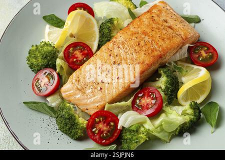 Gegrilltes Lachsfilet mit Gemüse, Brokkoli, Kirsche, Eisbergsalat, Gewürze und Kräuter, hausgemacht, keine Leute Stockfoto