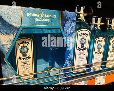 Kiew, Ukraine - 11. Februar 2025: Wunderschön gestaltete und arrangierte Bombay Saphir Gin Flaschen in einem Einzelhandelsgeschäft, die die Markenpräsentation hervorheben Stockfoto