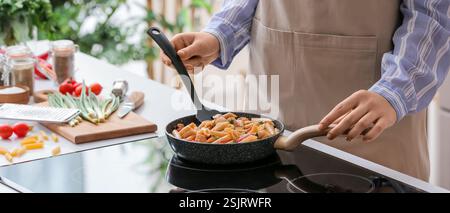 Frau kochen leckere Pasta in der Küche Stockfoto