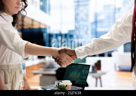 Geschäftspartner im Büro schütteln die Hände, nachdem sie einen lukrativen Vertrag für das Unternehmen abgeschlossen haben. CEO-Treffen mit Frau, mit einer Willkommensgeste, bevor das Gespräch beginnt Stockfoto