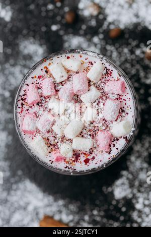 Tasse rosafarbene heiße Schokolade mit Marshmallows und Puderzucker auf einem rustikalen dunklen Hintergrund Stockfoto