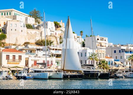 INSEL NAXOS, GRIECHENLAND - 29. September 2024: Segelboote vor Anker im Hafen von Naxos mit Altstadtgebäuden von Chora im Hintergrund. Stockfoto