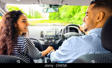 Liebevolles Paar, das die Hände hält, während es im Auto sitzt, Rückansicht Stockfoto