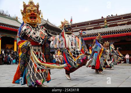Xining, China. 11. Februar 2025. Maskierte buddhistische Mönche führen am 11. Februar 2025 den Cham-Tanz auf, um für Frieden und Wohlstand im Kumbum-Kloster, auch bekannt als Ta'er-Tempel, in Xining, Provinz Qinghai in China zu beten. Der Cham-Tanz wurde 2006 als eines der nationalen immateriellen Kulturgüter aufgeführt. Quelle: Ma Mingyan/China News Service/Alamy Live News Stockfoto