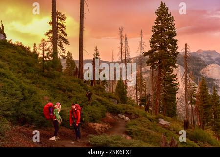 Wanderer, die nach einem Campingplatz nach Sonnenuntergang im Yosemite-Nationalpark auf einem Rucksackausflug suchen. Stockfoto