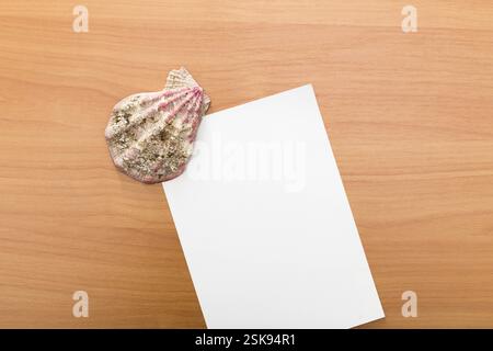 Die Schale liegt neben einem leeren Blatt Papier auf einer Holzoberfläche auf und sorgt für eine minimalistische Ästhetik Stockfoto
