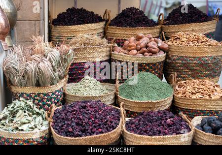 Verschiedene getrocknete Kräuter, Gewürze und Karkadetee werden auf dem ägyptischen Straßenmarkt verkauft. Ware in großen Korbkörben und in Regalen. Die Mauer des Himmels Stockfoto