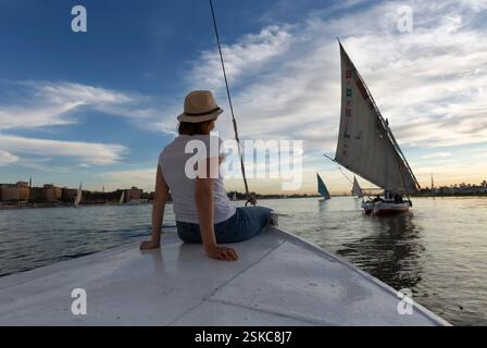 Erleben Sie eine Felukenfahrt auf dem Nil in Assuan mit pharaonischen Sehenswürdigkeiten und touristischer Freude. Genießen Sie eine traditionelle Felukenfahrt auf dem Nil. Stockfoto