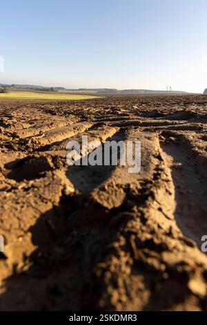 Spuren der Lauffläche von Automobilrädern auf dem gepflügten Boden des Feldes, Spuren von Zugmaschinen und anderen landwirtschaftlichen Maschinen auf dem Boden auf dem Feld Stockfoto