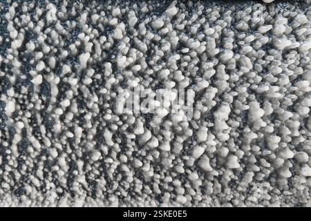 Eisschicht an der Autotür bei eisigem Regen auf der Straße, Hintergrund und Textur im Vollformat Stockfoto