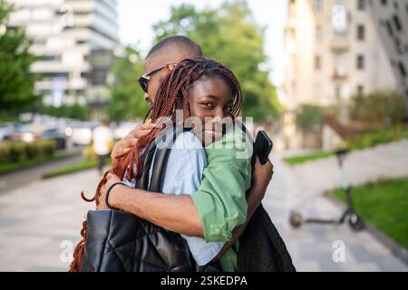 Trauriges afroamerikanisches Paar umarmt auf Wiedersehen, eine Frau, die nicht auf der Straße loslässt. Trennung, weg Stockfoto