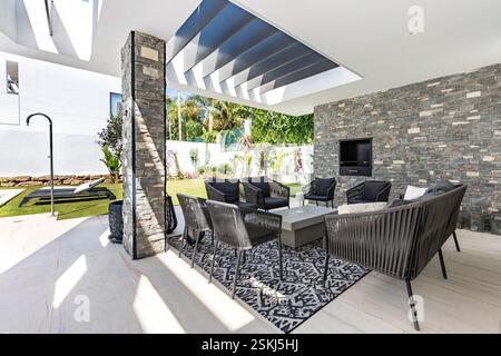 Ein Bild von einem Sitzbereich im Freien mit Kamin im Garten einer luxuriösen mediterranen Villa zum Verkauf Stockfoto