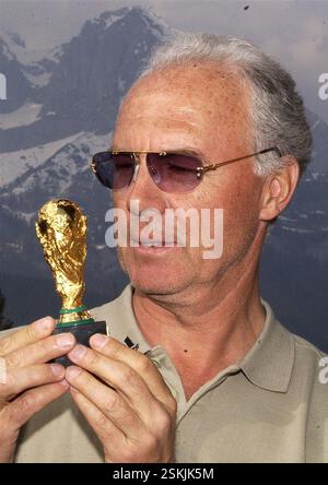 FOTO: WALTER L. KELLER, 5,4.2002, OBERNDORF/KITZBÜHEL (AUT): FRANZ BECKENBAUER, PRIVATIER, PRAESIDENT DES FC BAYERN MÜNCHEN UND OK-PRAESIDENT DER FUSSBALL-WM 2006 IN DEUTSCHLAND, POSIERT MIT EINER REPLIKA DES WM-POKALS VON 1990 VOR SEINEM HEIM. IM HINTERGRUND DER 'WILDE KAISER'.- RDB VON DUKAS Stockfoto