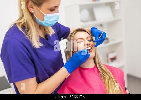 Zahnarzt bei der Untersuchung eines Patienten in einer zahnärztlichen Klinik. Junge Frau beim Zahnarzt. Stockfoto