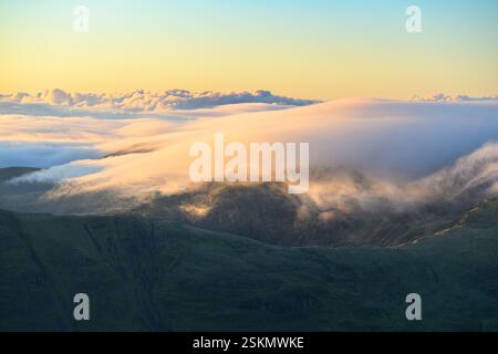 Wolken über den Bergen an einem schönen sonnigen Morgen von Helvellyn im Lake District, Großbritannien. Stockfoto