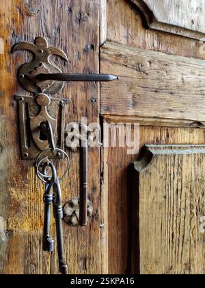 Bruchstück einer alten verwitterten Tür mit rostigem Griff und Schlüssel im Türschloss. Kopierbereich für Text. Stockfoto