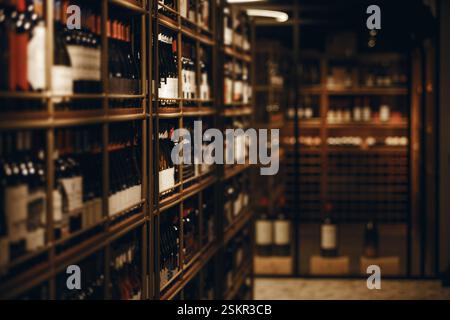 Exquisit aussehender Weinkeller mit verschiedenen eleganten alkoholischen Getränken, Nahaufnahme. Horizontale Innenaufnahme von Regalen für alkoholische Getränke. Stockfoto