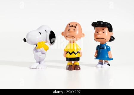 Die Figuren Snoopy, Charlie Brown und Lucy Van Pelt stehen auf weißem Hintergrund zusammen und repräsentieren ikonische Charaktere aus den Peanuts-Comics Stockfoto