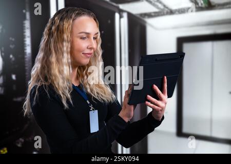 Junger professioneller Berater, der ein Tablet in einer modernen Rechenzentrumsumgebung verwendet Stockfoto