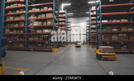 Logistics Distribution Center: Automatisierte Guided Vehicles für den Transport von Kartonagen im modernen Einzelhandelslager. AGV-Roboter, die Pakete mit Produkten und Waren transportieren und liefern. 3D Future Technology Stockfoto