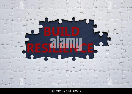 Symbol für Belastbarkeit erstellen. Weißes Puzzle mit Wörtern schafft Widerstandsfähigkeit. Wunderschöner dunkelblauer Hintergrund. Business- und Build Resilience-Konzept. Kopierbereich. Stockfoto