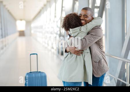 Romantik Bei Der Ankunft. Afrikanisches Paar, Das Sich Zärtlich Im Flughafenkorridor Umschließt, Nachdem Es Sich Lange Zeit Nicht Gesehen Hat Stockfoto