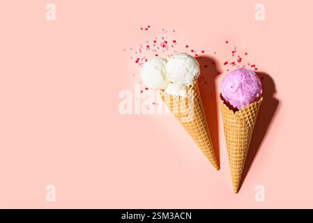 Zwei Eiskegel mit herzförmigen Zuckerstreuseln auf rosa Pastellhintergrund, Draufsicht, Kopierraum. Valentinstag, süße Liebe und lustige Sommer-des Stockfoto
