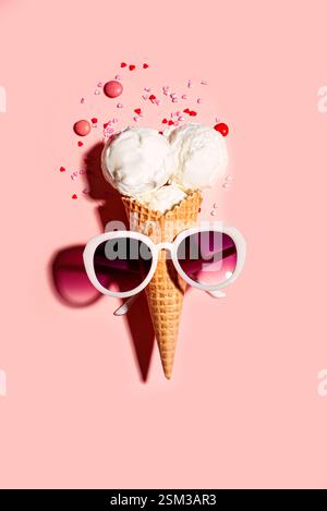 Kreatives Sommerkonzept mit lustiger Eisbecher und Sonnenbrille auf rosa Pastellhintergrund mit Streuseln, Kopierraum. Trendiger Strand Relax und Sommer Stockfoto