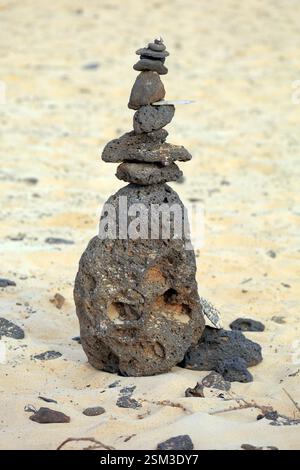 Gestapelte vulkanische Steine an einem Sandstrand, El Cotillo, Oliva, Fuerteventura, Kanarische Inseln, Spanien. Stockfoto