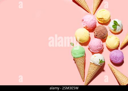 Verschiedene Eiskugeln mit verschiedenen Geschmacksrichtungen auf rosa Pastellhintergrund, Draufsicht, Kopierraum. Eis oder Eis mit Waffelkegeln, gesunder Sommer Stockfoto