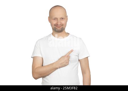 Ein kahler Mann mit weißem T-Shirt zeigt mit selbstbewusstem Ausdruck zur Seite. Stockfoto