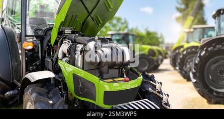 Landmaschinenindustrie. Inspektion eines modernen Traktormotors in einem Händlerbetrieb Stockfoto