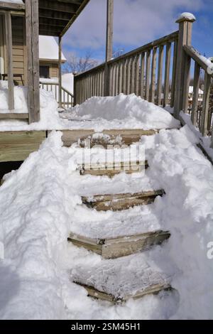 Ein Pfad wurde von dem tiefen Winterschnee auf der Treppe auf dem hinteren Deck eines Hauses befreit. Stockfoto