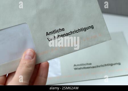 12. Februar 2025 - Hamburg, Deutschland. Schließen Sie eine Hand, die einen Stimmbescheid für den Wahltag hält Stockfoto