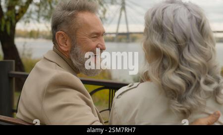 Glückliche Familie Senior Rentner kaukasischer 60er Mann lachen Lächeln mit Frau romantisches Date Wochenende im Stadtpark fröhlich fröhlich alte männliche Frau lacht Stockfoto