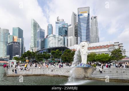Touristen genießen den Merlion-Brunnen in Singapur inmitten von Wolkenkratzern. Stockfoto