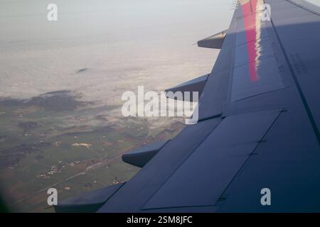 Wolken und Himmel gesehen durch Fenster eines Flugzeugs Stockfoto