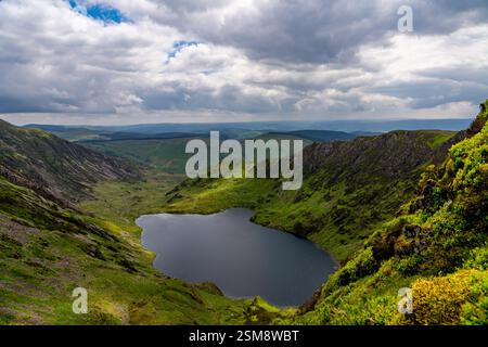 Atemberaubende Aussicht auf Llyn Cau aus der Vogelperspektive, eingebettet in die zerklüfteten Gipfel von Cadair Idris unter dem dramatischen Wolken-Laden-Himmel Stockfoto