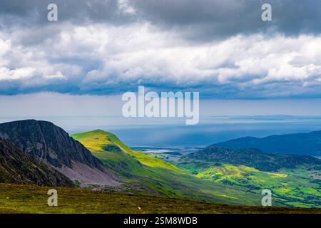 Atemberaubender Blick auf die Barmouth Bay und die Küstenlandschaft beleuchtet durch dramatisches Licht vom Gipfel des Penygader (Cadair Idris) Stockfoto