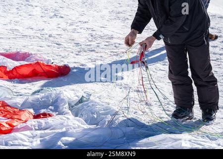 Paraglider entwirren Kite Lines vor dem Start über die französischen Alpen an einem sonnigen Tag Stockfoto