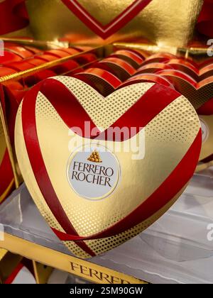 Italien - 12. Februar 2025: Ferrero Rocher in goldener Herzform mit rotem Band als Valentinstag-Geschenk zum Verkauf im Supermarkt Stockfoto