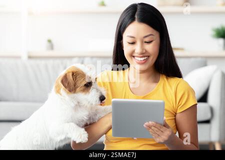 Asiatische Frau und niedlichen Hund mit Spaß zusammen zu Hause Stockfoto