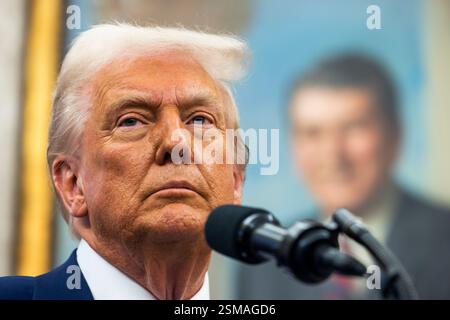 Washington, DC, USA. Februar 2025. Das offizielle Porträt des ehemaligen US-Präsidenten Ronald Reagan ist hinter US-Präsident Donald Trump abgebildet, als er am 12. Februar 2025 im Oval Office des Weißen Hauses in Washington, DC, USA, mit den Medien spricht. Trump sprach nach der Vereidigung seines Kandidaten für den Direktor des Nationalen Geheimdienstes Tulsi Gabbard. Quelle: Jim LoScalzo/Pool über CNP/dpa/Alamy Live News Stockfoto