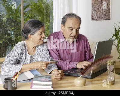 Altes Paar, das Laptop mit Kreditkarte MR#702T, 702S bedient Stockfoto