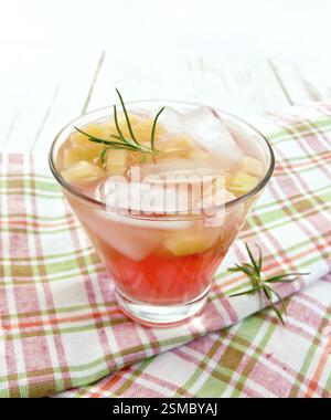 Limonade mit Rhabarber und Rosmarin in einem Glas auf einem Rosa kariert Serviette auf einem hölzernen Brettern Hintergrund Stockfoto